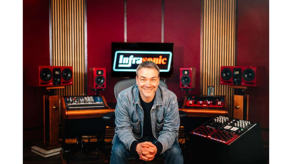 Dr. Frederik Knop smiling in front of a mixing console at Infrasonic Sound professional recording studio.