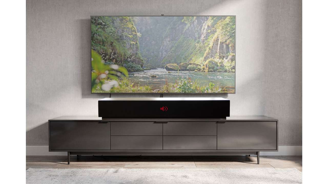 LIVEBOX soundbar beneath a television on a lowboard, with a landscape image above on a gray wall in the living room