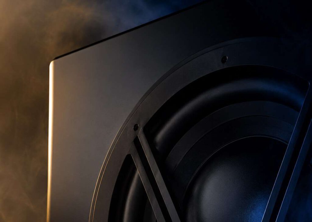 Velodyne Acoustics 1824 subwoofer with large woofer, black enclosure and V-shaped protective grille in the dark
