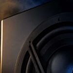 Velodyne Acoustics 1824 subwoofer with large woofer, black enclosure and V-shaped protective grille in the dark